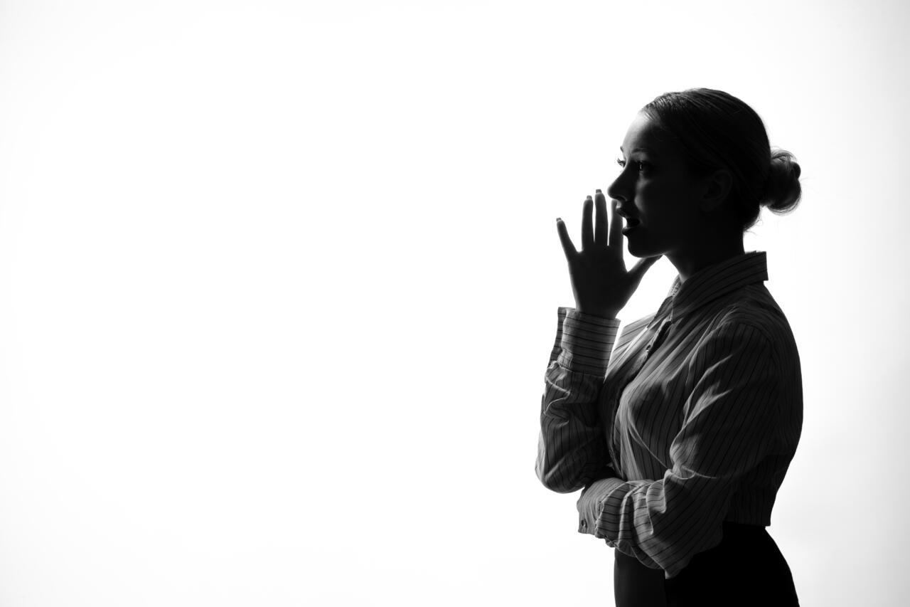 female person silhouette calling someone side viewshadow back lit white background young